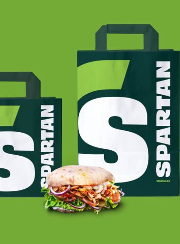 Takeaway packaging featuring modern Spartan logo and colors.