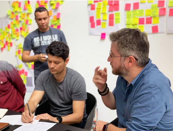 Rainfall Branding team in a brand strategy workshop, collaborating with sticky notes to plan structure, teamwork, and creative solutions for clients.